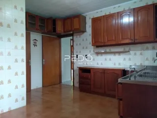 Cozinha com armários de madeira e piso de cerâmica no imóvel.