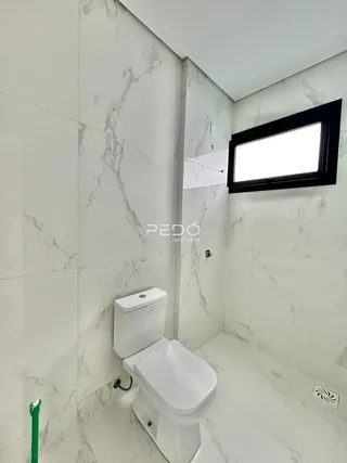 Foto de um banheiro com revestimento em mármore branco.