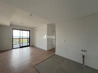 Sala de estar com piso de madeira e grande janela.
