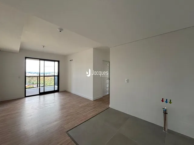 Sala de estar com piso de madeira e grande janela.