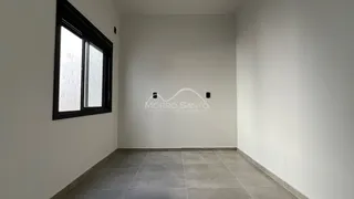Foto de um corredor interno com paredes brancas e piso de cerâmica.