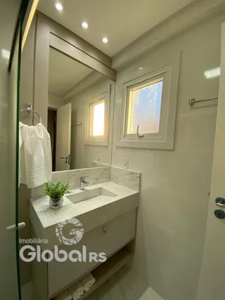 Foto de um banheiro com bancada e box de vidro.