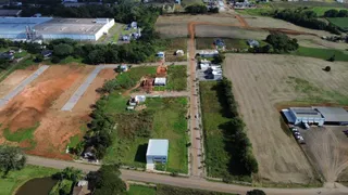 Vista aérea de um terreno com áreas de campo e estruturas dispersas.
