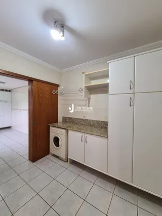 Foto de uma cozinha com armários brancos e piso de cerâmica.
