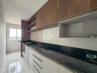 Vista da cozinha com armários de madeira e bancada escura.