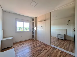 Interior de um cômodo com piso de madeira e paredes brancas.
