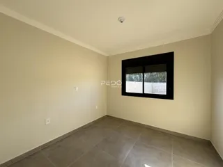 Vista interna de um ambiente com paredes claras e piso de cerâmica.