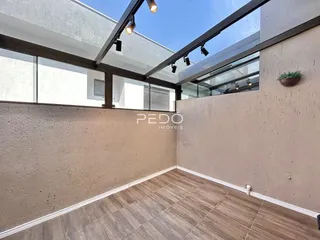 Foto de uma área interna com piso de madeira e paredes texturizadas.