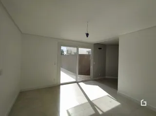 Vista interna de um ambiente com paredes brancas e piso claro.