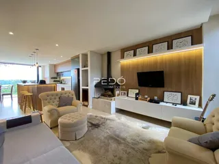 Sala de estar moderna com cozinha integrada e lareira em um imóvel no Brasil.