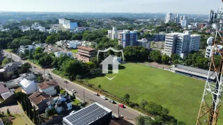 Vista aérea de uma propriedade com grande gramado e entorno residencial.