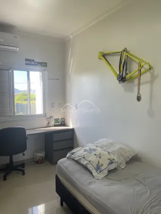 Quarto com cama e janela mostrando a vista externa.
