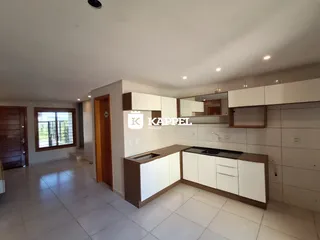 Cozinha moderna com armários brancos e piso de cerâmica.