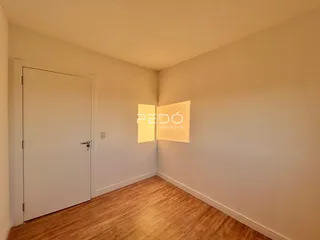 Hall de entrada com piso de madeira e paredes brancas.