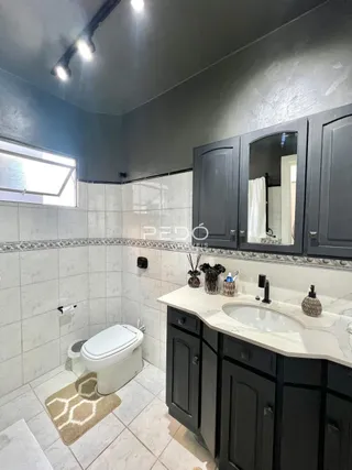 Foto de um banheiro com revestimento cerâmico e louças sanitárias.