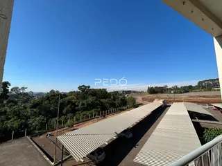 Vista da propriedade com vegetação e trilhos de trem.
