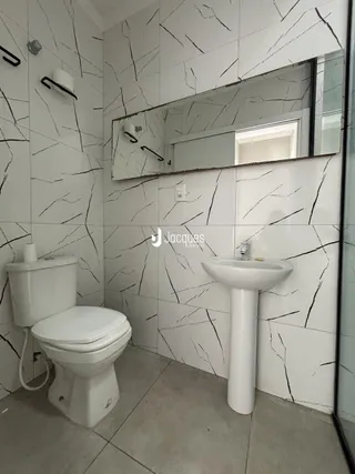 Foto de um banheiro com revestimento de azulejos pretos e brancos.