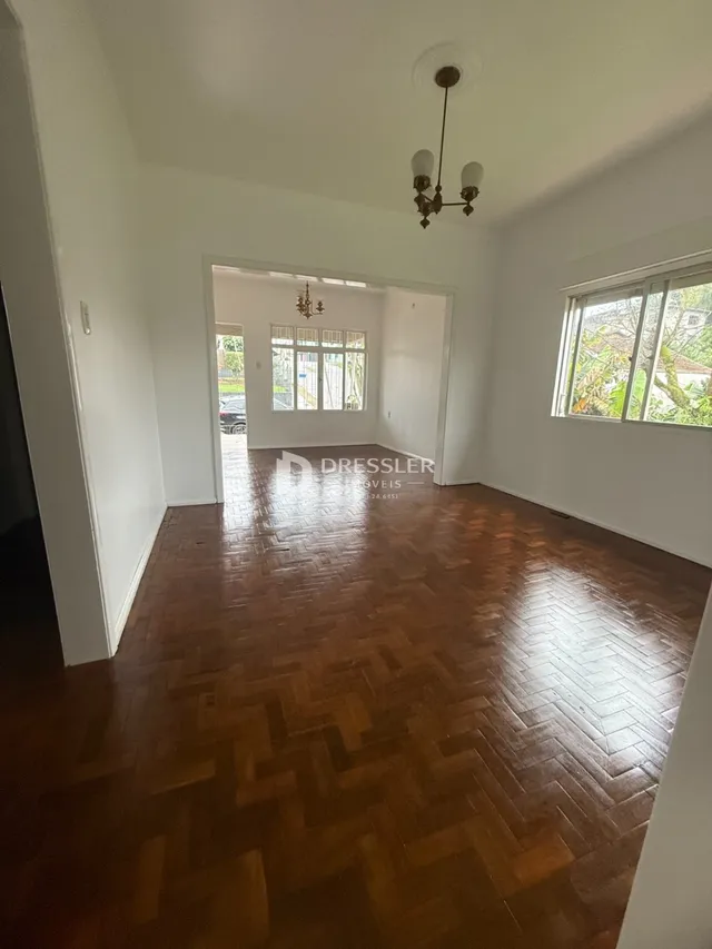 Uma sala de estar com piso de madeira no interior da residência.