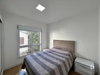 Quarto com cama e janela em uma residência.