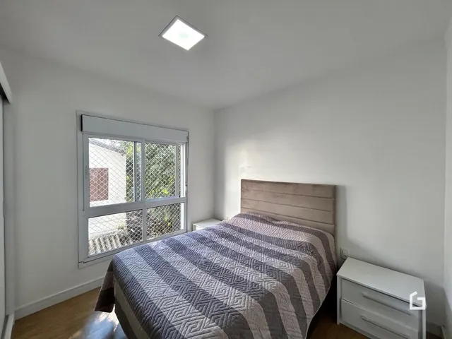 Quarto com cama e janela em uma residência.
