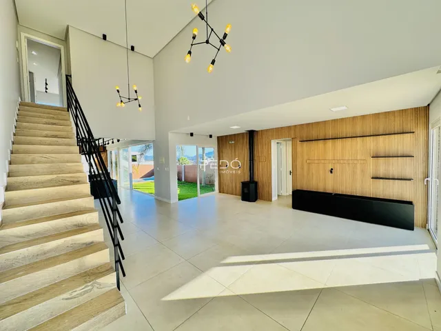 Interior de uma sala de estar moderna com escadaria e piso claro.