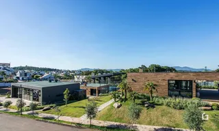 Vista externa de uma residência moderna com jardim.