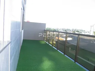 Vista da varanda com piso de grama artificial e grade de vidro.