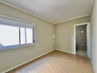 Ambiente interno com paredes claras e piso de madeira em um imóvel.
