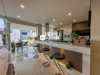 Vista da sala de estar com bancada e área de jantar em um imóvel.