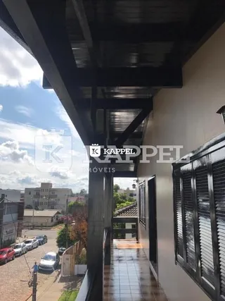 Hall de corredor com piso de ladrilho e estrutura de teto escura.