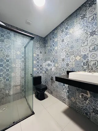 Interior de um banheiro com revestimento de azulejos azuis e brancos.
