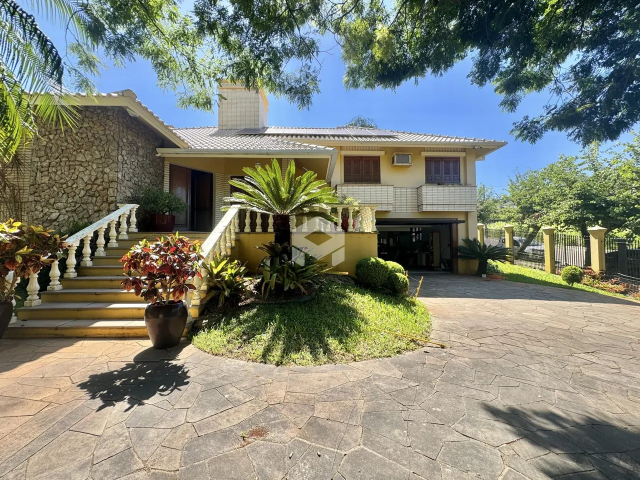 Fachada de uma casa em Lajeado, Brasil, com jardim e escadaria.