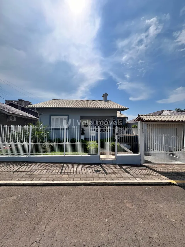 A fachada de uma residência em Lajeado, Brasil, com cerca e portão branco.