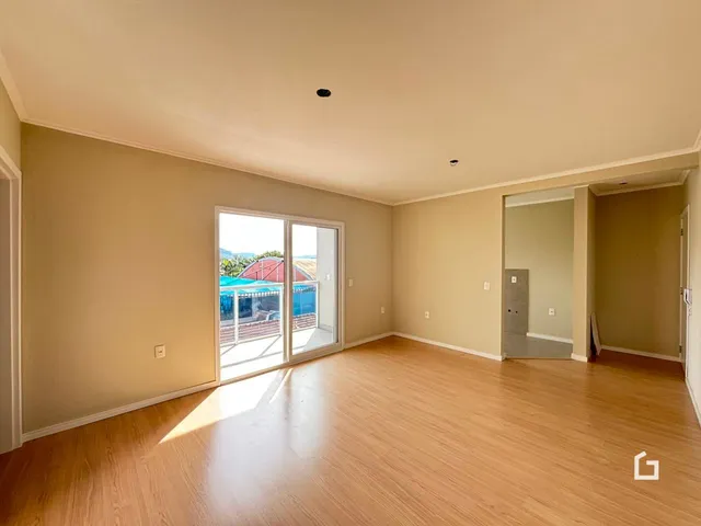 Sala de estar com piso de madeira clara e porta de vidro abrindo para o exterior.