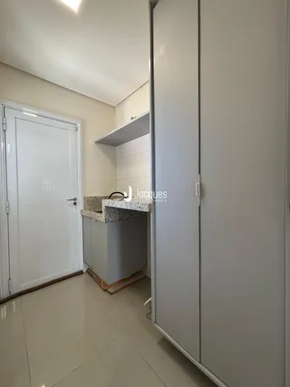 Hall de entrada com cozinha e armário em um imóvel no Brasil.