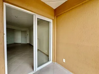 Foto de um corredor interno com piso de cerâmica e paredes amarelas.