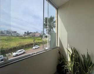 Vista da janela de uma residência em Lajeado, Brasil, mostrando uma paisagem verde.