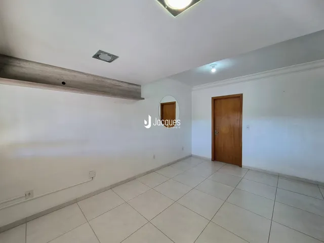 Interior de uma sala com piso de cerâmica clara e paredes brancas.