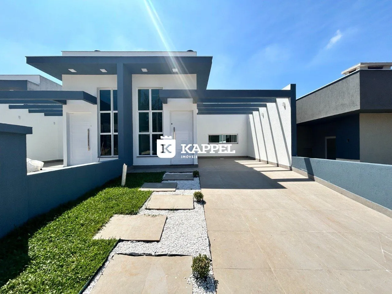 Fachada de uma casa moderna em Lajeado, Brasil, com revestimento em tons de cinza e branco.