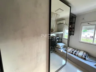 Quarto com janela e espelho refletindo o interior da sala.