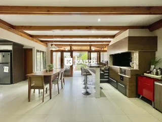 Uma sala de jantar ampla com mesa de madeira e lareira.