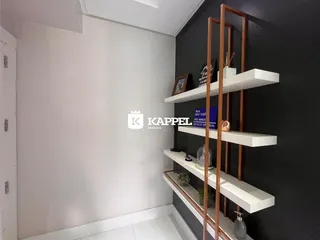 Foto de um corredor interno com paredes brancas e escuras e prateleiras de madeira.