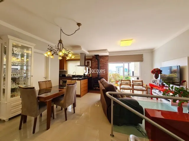 Ambiente interno com mesa de jantar de madeira e luminária no interior da residência.