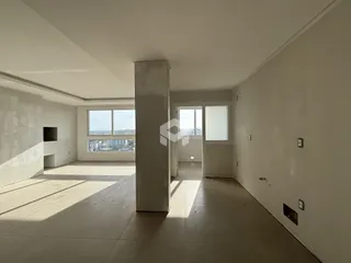 Interior de um ambiente amplo com piso de cerâmica e vista para a paisagem.