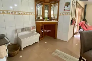 Uma sala interna com paredes brancas e móveis de madeira.