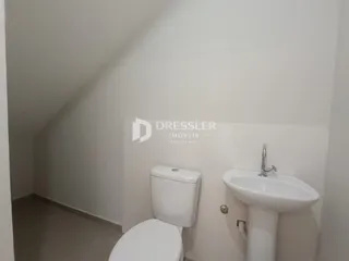 Foto de um banheiro com vaso sanitário e pia brancos.