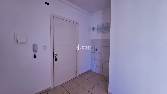 Hall de entrada com portas brancas e piso de cerâmica.