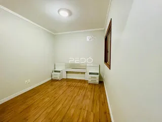 Quarto com piso de madeira e armários embutidos em uma sala.