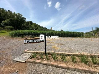 Foto da entrada de estacionamento com sinalização em uma área externa.