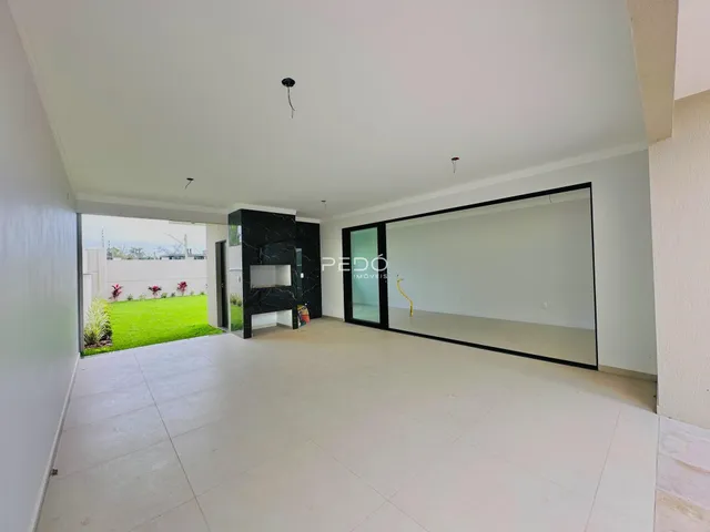 Ambiente interno amplo com vista para o jardim externo.